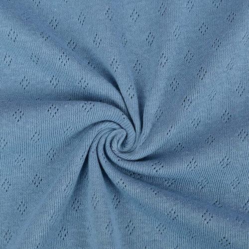 Vintage blue pointelle knit jersey fabric from Once Upon A Fabric with diamond-shaped perforations. The pointelle cotton jersey fabric appears lightweight, suggesting it may be perfect for baby clothes or accessories.