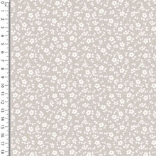 Load image into Gallery viewer, A swatch of Oeko-Tex 100 certified fabric featuring a small, white floral pattern on a soft beige background. A white ruler with black markings is placed vertically on the left side, measuring up to 18 centimeters. This Cotton Jersey Fabric - Millefleur Taupe by Once Upon A Fabric is perfect for dressmaking projects.
