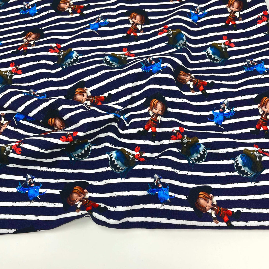 A Cotton Jersey Fabric - Pirate Navy with a navy blue and white striped pattern featuring cartoon characters. The characters include several wearing red outfits, blue outfits, and various other colors, spaced evenly across the fabric's surface. Ideal for baby clothes and Oeko-Tex 100 certified for safety by Once Upon A Fabric.