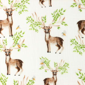 A double gauze fabric featuring a pattern of illustrated deer with large antlers and green foliage. The background is white, and small birds are interspersed among the deer and leaves, making it perfect for baby cotton apparel. This is the REMNANT 63 CM Double Gauze - Stag from Once Upon A Fabric.