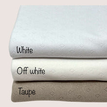 Load image into Gallery viewer, Three folded knit fabrics are stacked in a pile. The top fabric, perfect for baby clothes fabric, is labeled &quot;Pointelle Jersey - White&quot; from Once Upon A Fabric. The middle Oeko-Tex 100 certified fabric is labeled &quot;Off white,&quot; and the bottom Pointelle cotton jersey is labeled &quot;Taupe.&quot; Each fabric has a subtle textured pattern.
