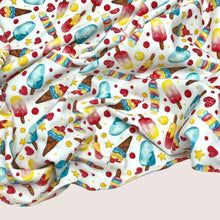Load image into Gallery viewer, A printed Cotton Jersey Fabric - Ice Cream with a colorful pattern of various ice creams, including popsicles and cones in shades of red, blue, yellow, and brown. Slightly crumpled to highlight the illustrations, this Oeko-Tex 100 certified material from Once Upon A Fabric is perfect for creating adorable baby clothes.
