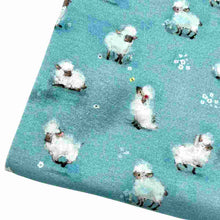 Load image into Gallery viewer, Baby fabric features a delightful pattern of small white sheep on a blue background, interspersed with tiny white flowers.
