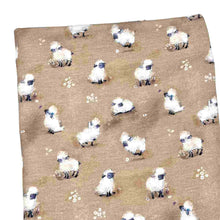 Load image into Gallery viewer, Baby fabric features a delightful pattern of small white sheep on a beige background, interspersed with tiny white flowers.
